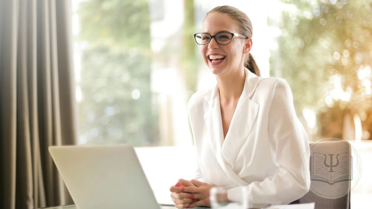 Psicóloga sonriente trabajando con su portátil mientras digitaliza la gestión de su consulta de psicología