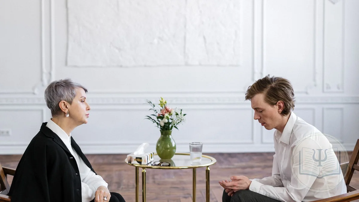 Psychologist listening reflectively to a client during a motivational interviewing session in a bright office