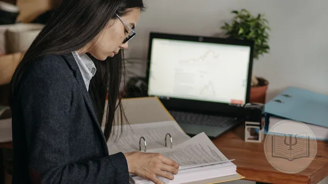 Psicóloga revisando la ficha y el historial de una paciente en su consulta, con el ordenador al lado