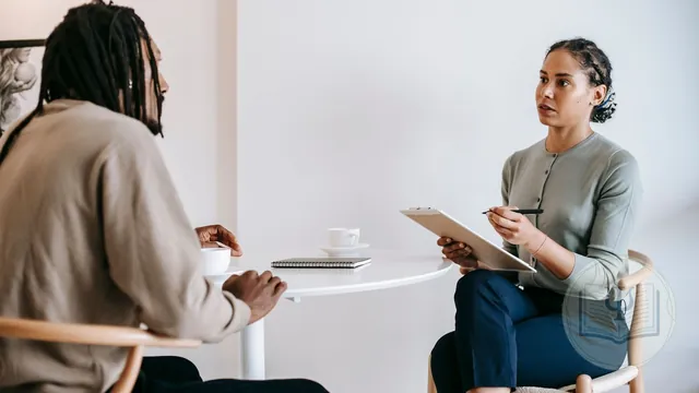 Psicóloga evaluando a un paciente y tomando notas para un informe psicológico