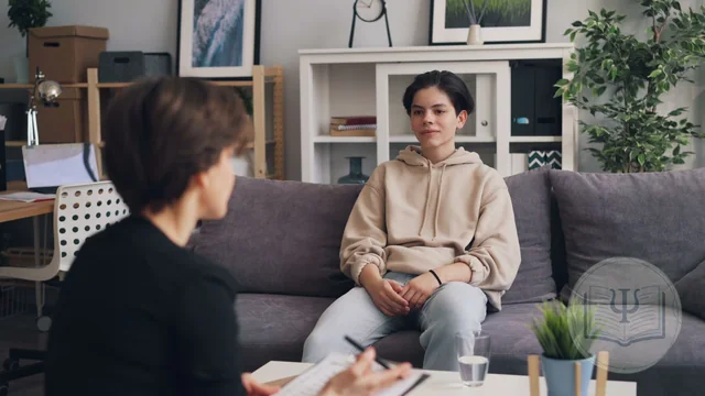 Psicóloga tomando notas durante la sesión con un paciente adulto joven en una consulta luminosa
