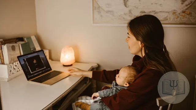 Madre reciente con su bebé en brazos frente al portátil en casa durante una sesión online de psicología perinatal