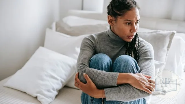 Mujer preocupada abrazándose las rodillas: el trastorno de ansiedad generalizada (TAG)